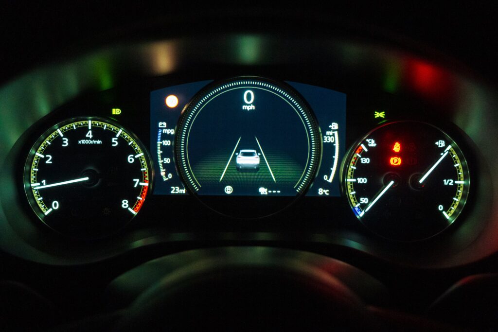 Engine Repair - Picture of a car's dashboard display illuminated during nighttime driving conditions.