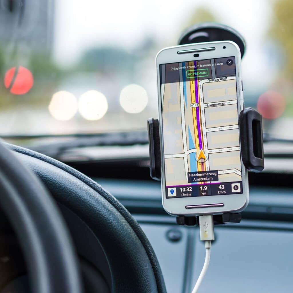 Image of a car accessory. Namely, a cell phone in a car cell phone holder attached to a windshield.